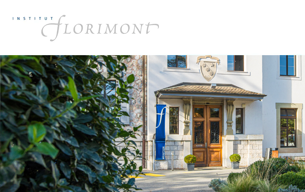 Entrance of Institut Florimont building with wooden double doors, shield emblem above, and a blue reception sign on the left.