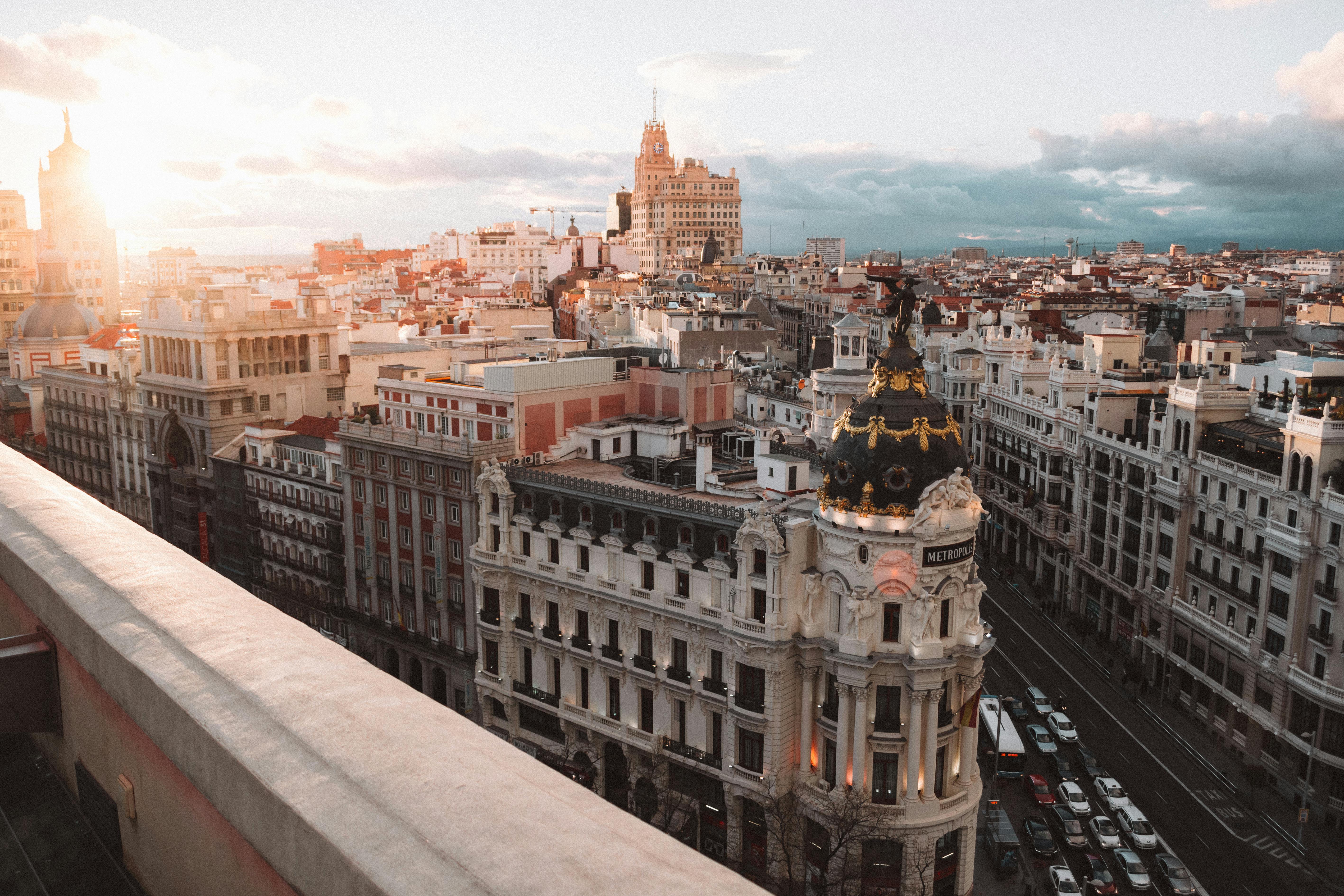 View of Madrid cityscape with the Metropolis building in the foreground during sunset.